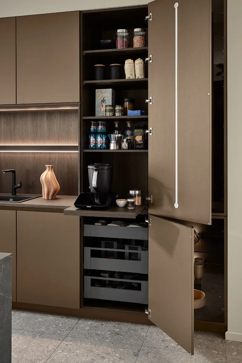 Geöffneter Hochschrank mit Pocket-Door und ausziehbarer Arbeitsplatte als Vorrats- und Kaffeestation