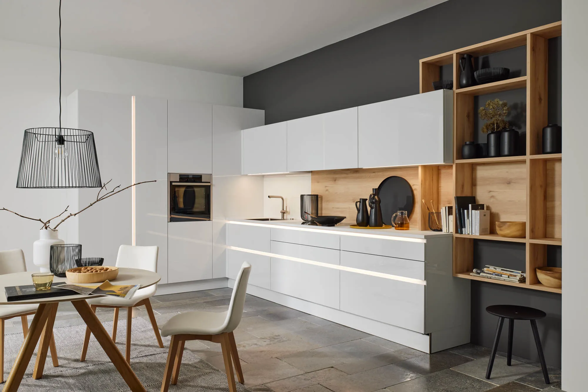 Elegante Designküche mit blauer Wand und offenem Wohnbereich bei Broßler.