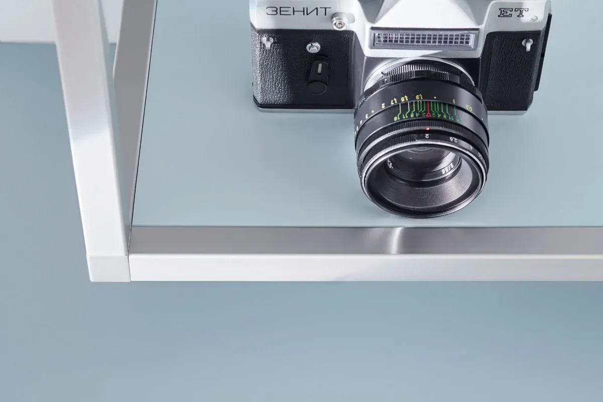 Detail eines Wandregals mit Vintage-Spiegelreflexkamera als Deko-Objekt