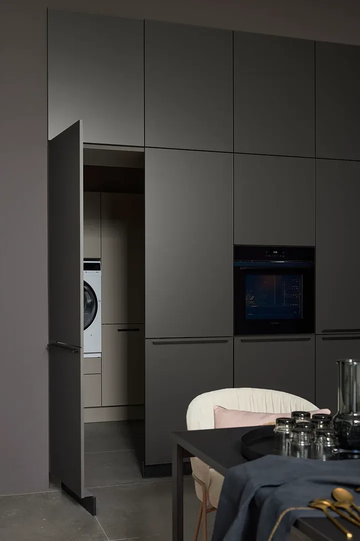 NOLTE Küche Pearl Umbra Metallic – Schrankwand mit geöffneter Tür zum Hauswirtschaftsraum