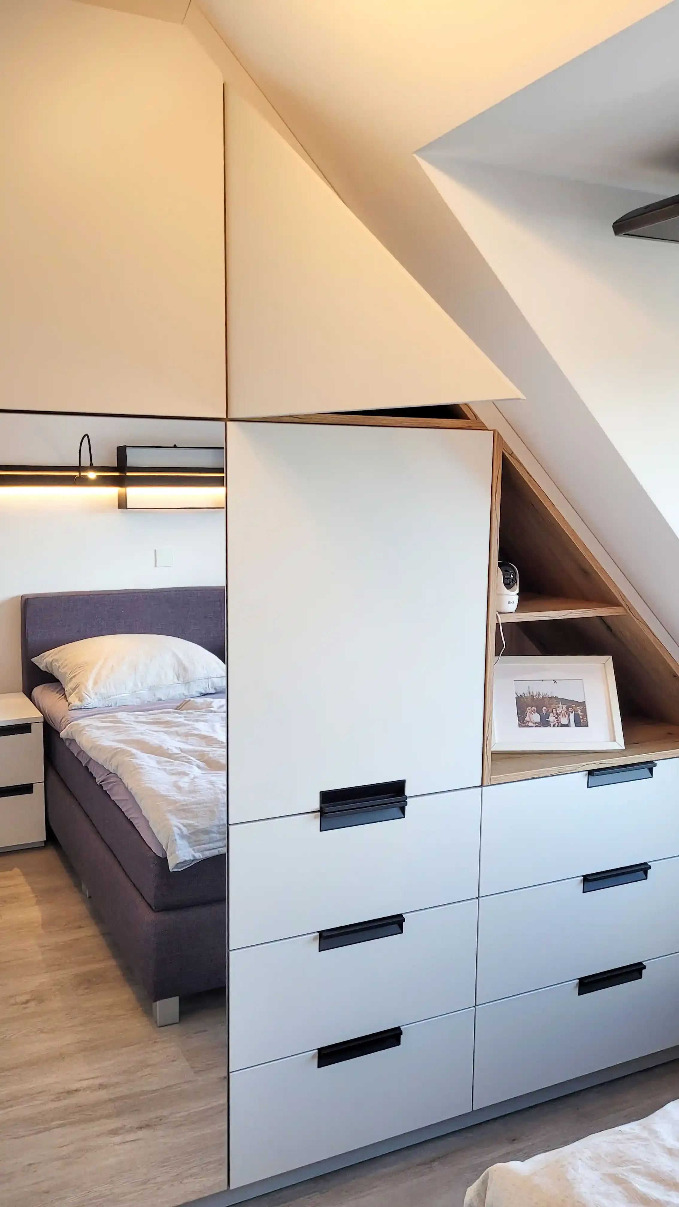 Maßgefertigter Einbauschrank unter Dachschräge mit sechs Schubladen und offener Bilder-Nische.