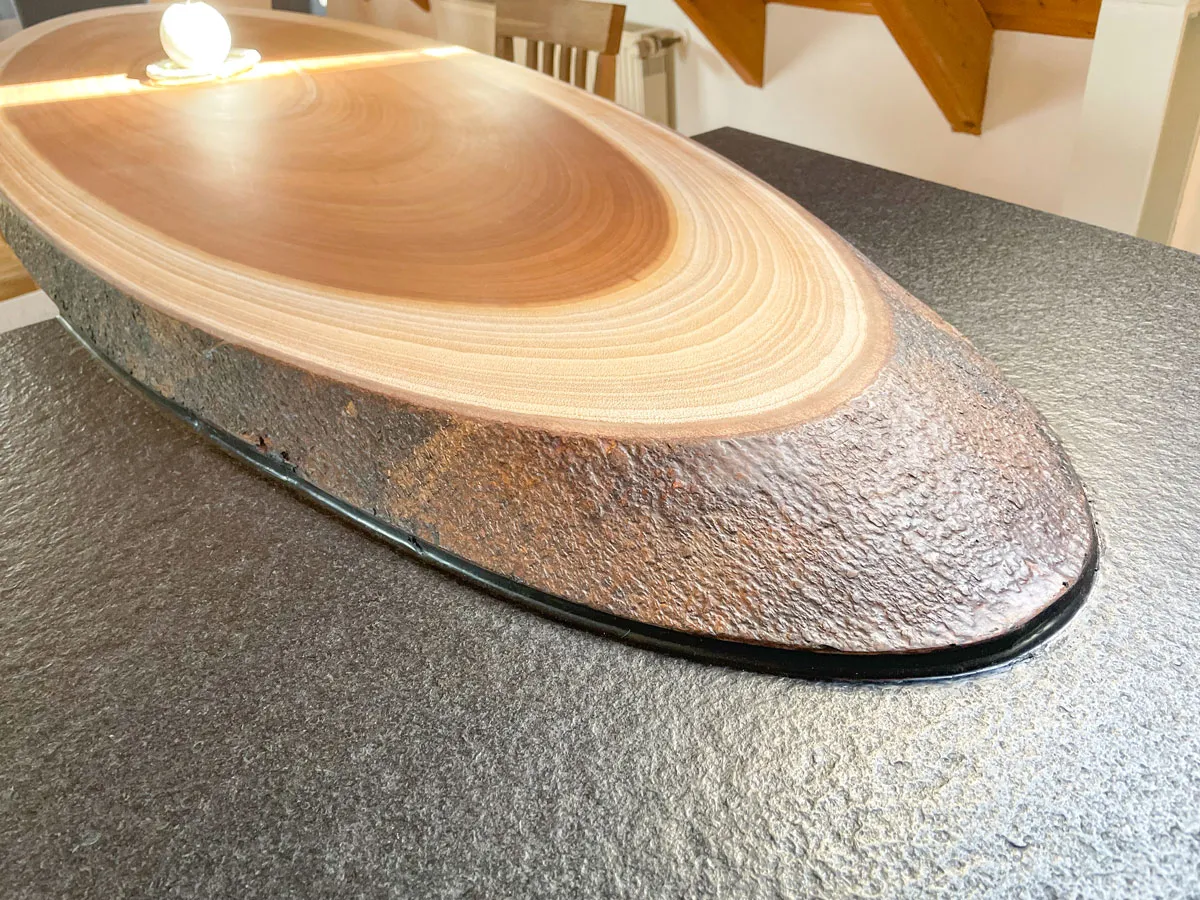 Naturbelassene ovale Massivholz-Tischplatte auf Steinsockel als Esstisch-Detail