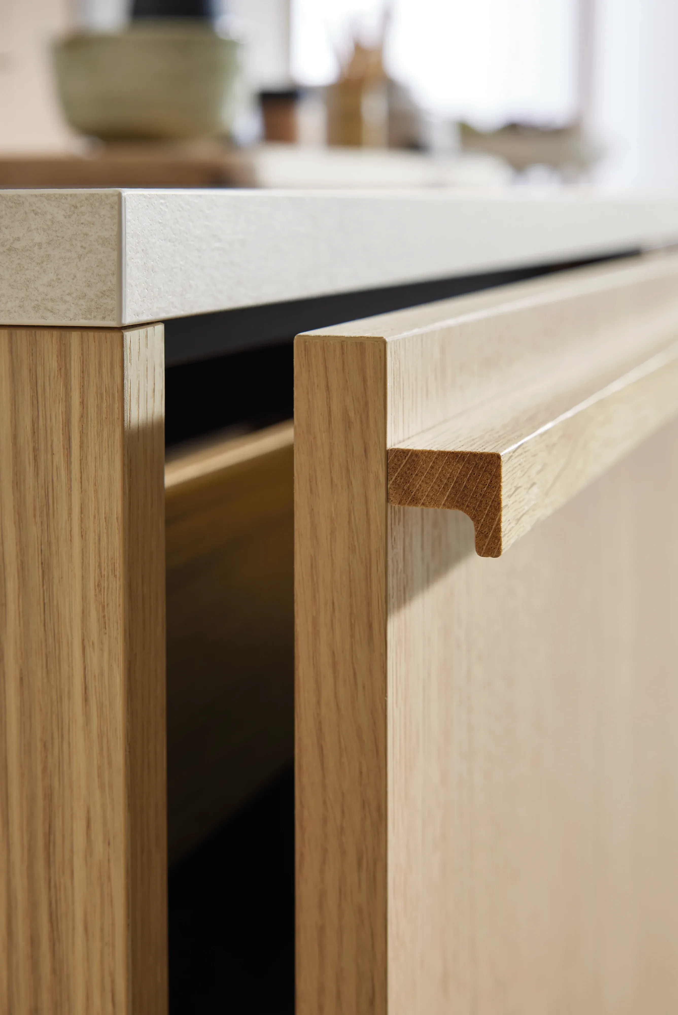 Materialnahaufnahme einer Sideboard-Schublade in heller Eiche mit massiver Holz-Griffmulde