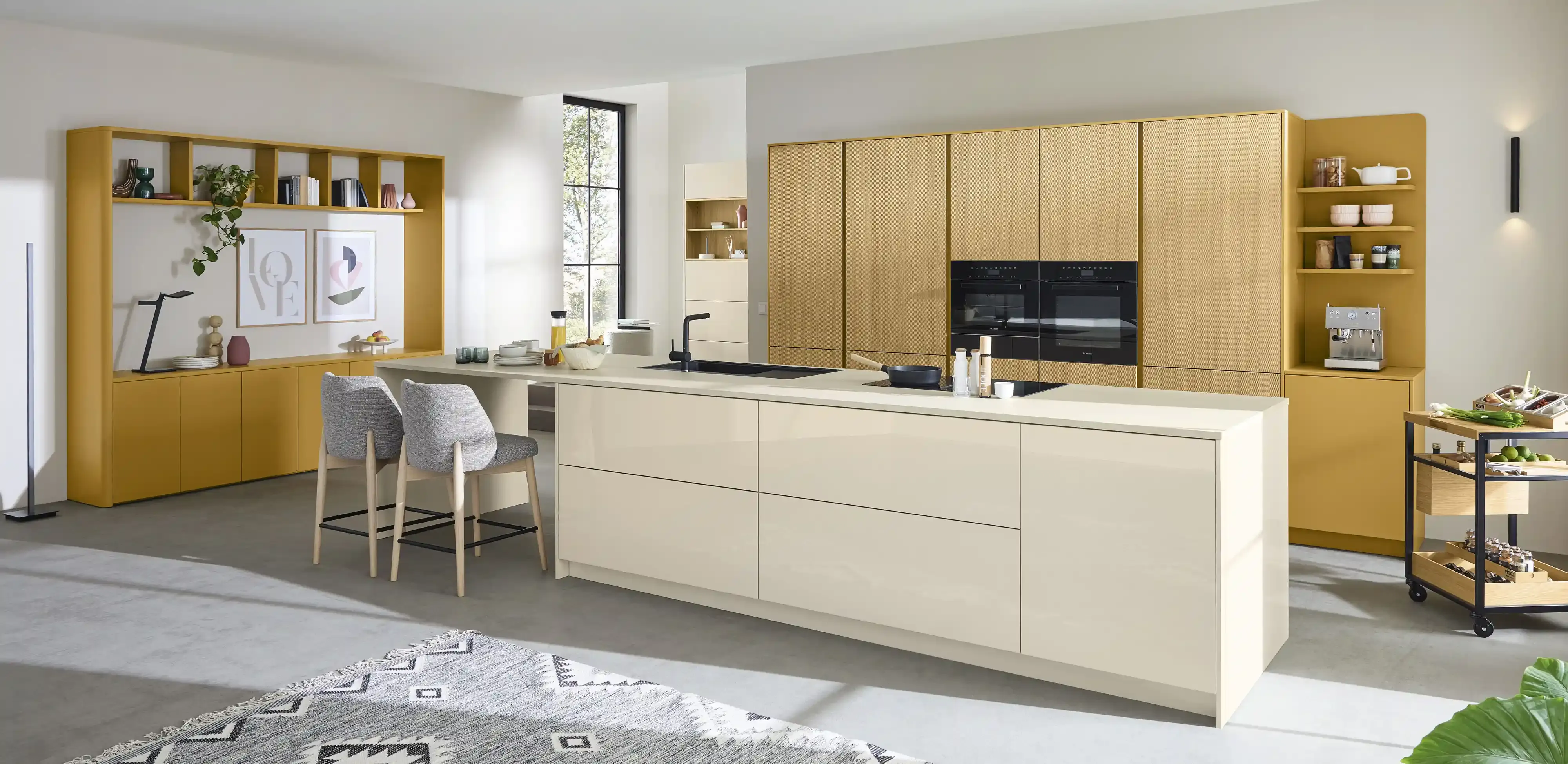 Offene Wohnküche mit Magnolie-Hochglanz-Kocheinsel, raumhoher Esche-Schrankwand, senfgelbem Sideboard und Essbereich