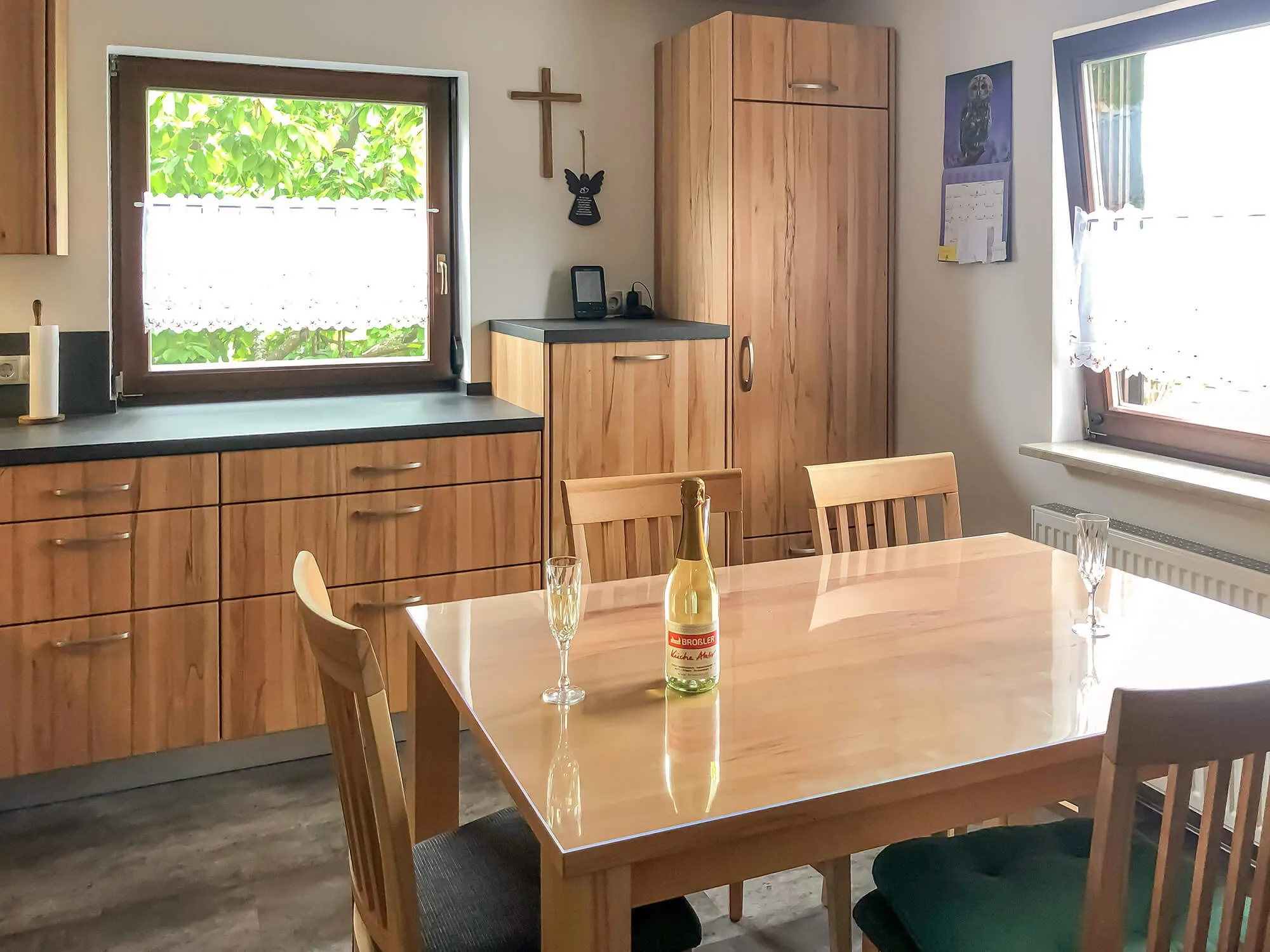 Essplätze in Küche mit massivem Holztisch, Holzstühlen und Küchenzeile in warmem Holzdekor