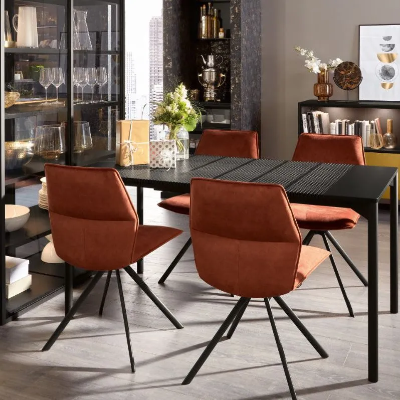 Dunkler Esstisch mit Cognac-Lederstühlen und Geschenken in eleganter Wohnküche