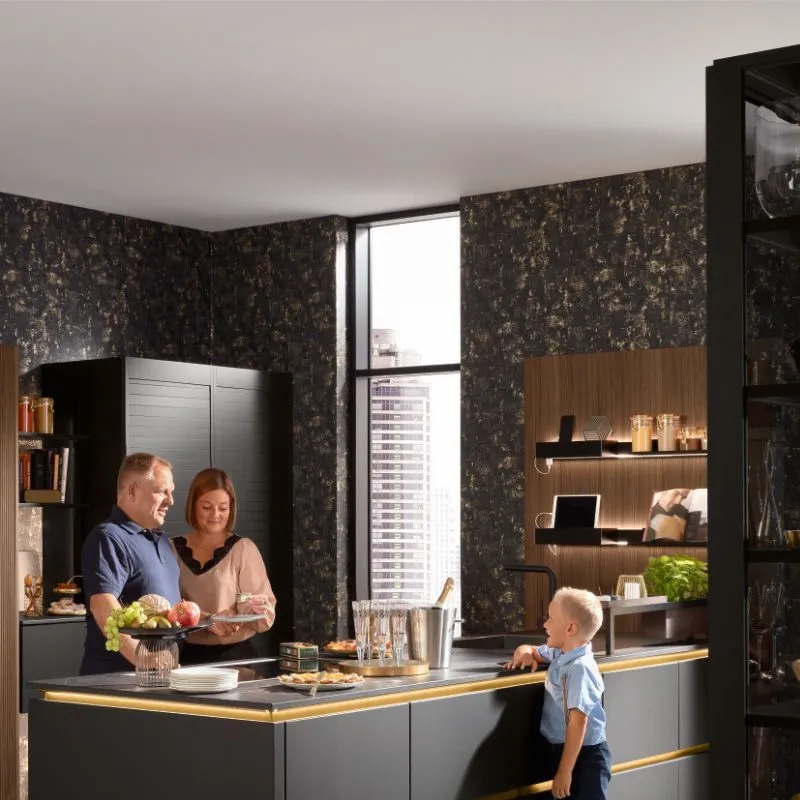 Familie beim Brunch an dunkler Kücheninsel mit goldenem LED-Sockelband