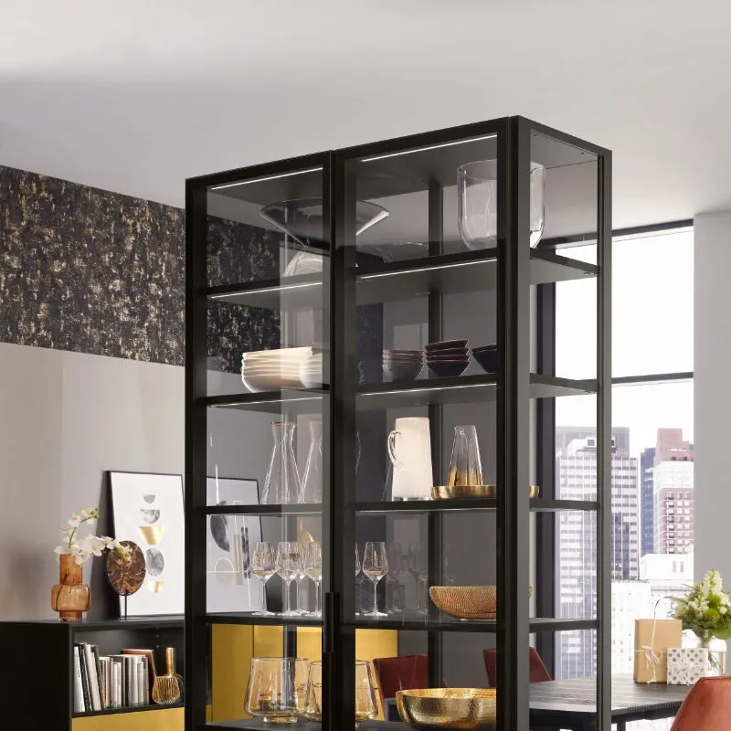 Raumhohes schwarzes Vitrinen-Highboard mit Glaswaren, Geschirr und goldenem Sockel