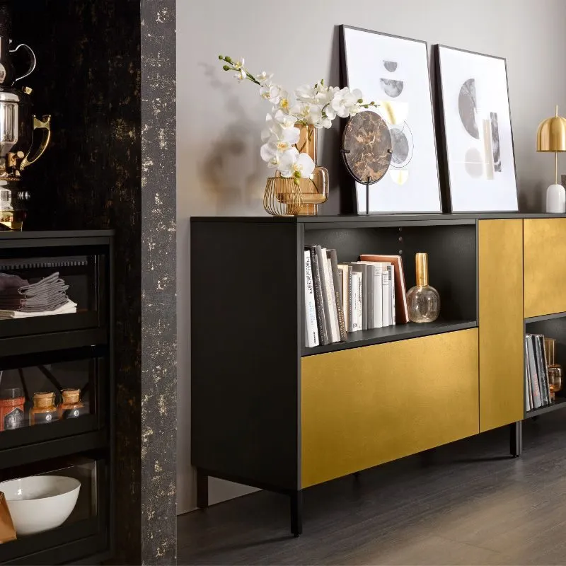 Wohnliches Sideboard in Schwarz mit goldener Akzent-Front, Vitrinen-Highboard und Orchideen-Deko