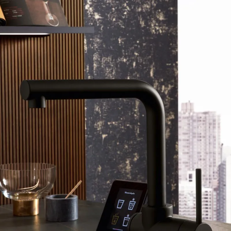 Schwarze Spül-Armatur mit Touch-Display für Heisswasser und Sprudelwasser an dunkler Holzlamellen-Wand