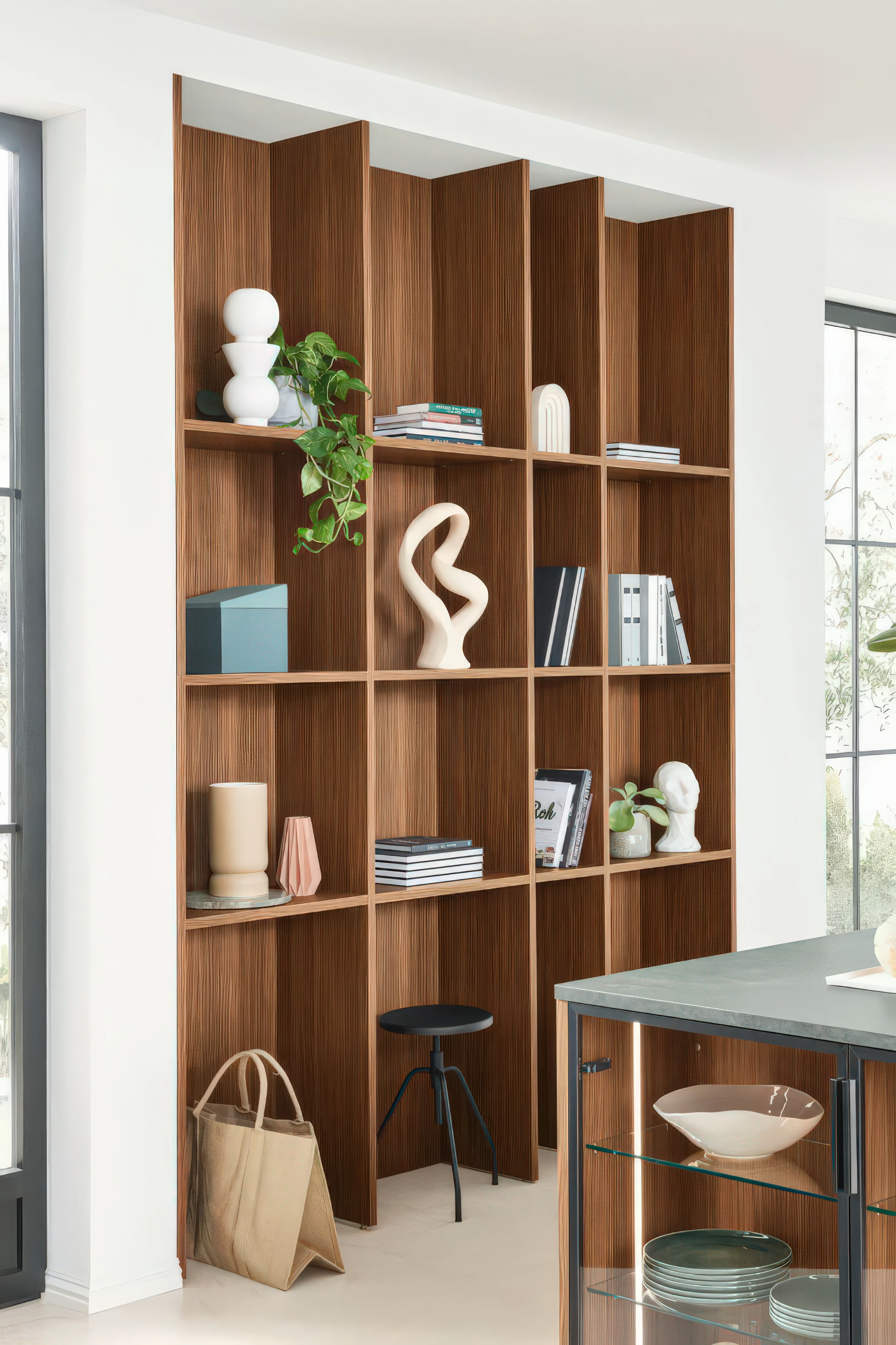 Raumhohes offenes Holzregal in Nussbaum mit Büchern, Vasen, Skulpturen und Kerzen als Wohnzimmer-Erweiterung der Küche